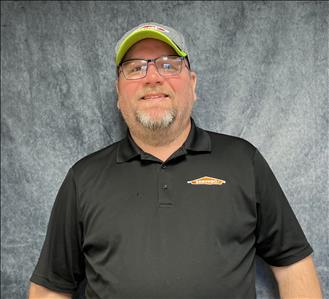 Male employee standing in front of grey backdrop